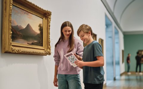 Two children looking at a bingo card in one of the galleries.