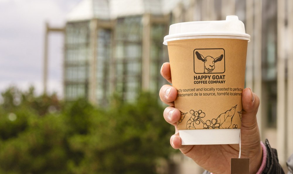 A Happy Goat coffee cup being held outside of the NGC.