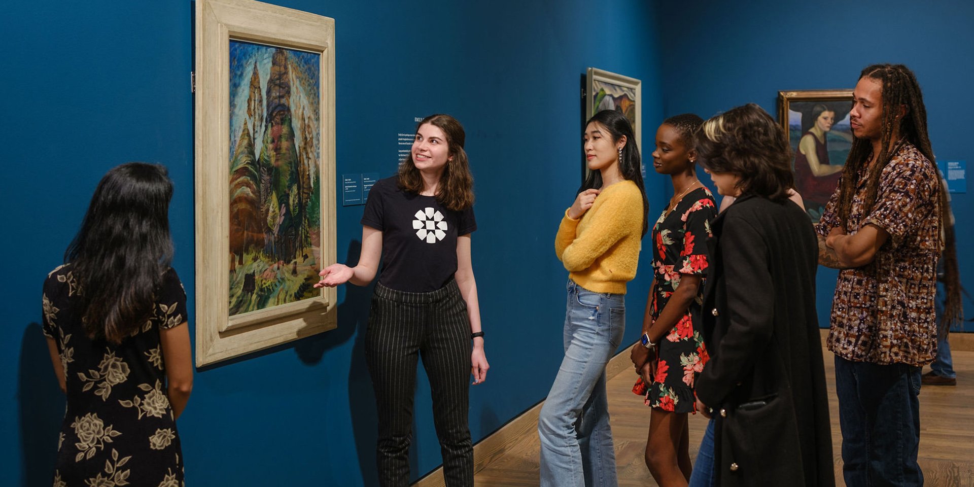 A Gallery guide discusses an artwork with a group of students.