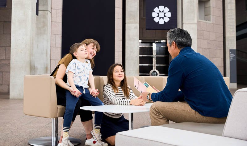 A family sitting together in the Scotiabank Great Hall.